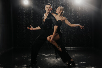 Fototapeta na wymiar A couple of dancers on a black background in a studio in the aqua zone