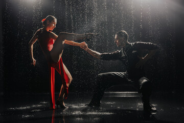 Fototapeta na wymiar A couple of dancers on a black background in a studio in the aqua zone