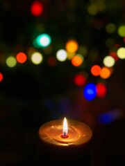 Candle is burning against blurred lights