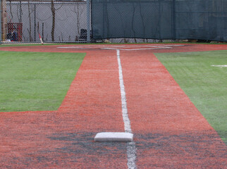 Fototapeta premium Looking down the foul line from third base to the batter box of a turf baseball field