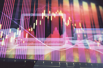 Financial chart drawing and table with computer on background. Multi exposure. Concept of international markets.