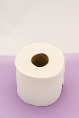 Roll of toilet paper on purple table.