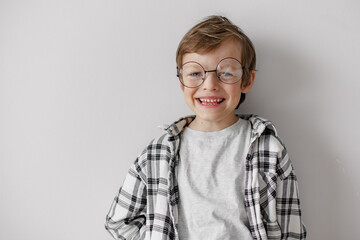 Happy school boy with big smile. Pupil in glasses on grey background. Home education.