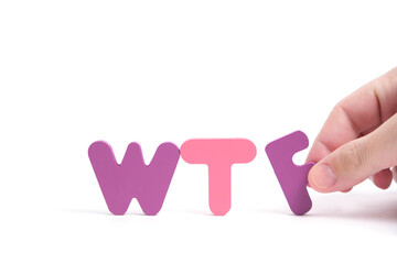 Man hand exposes abbreviation wtf in letters white background.
