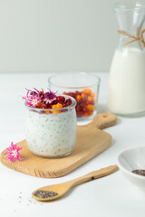 Superfood Pudding with chia seeds and edible flowers. Close-up, on a light background, vertical