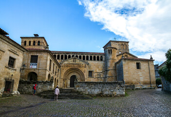 People visiting an old church of Colegiata de santa Juliana, with a beautiful blue cloudy sky