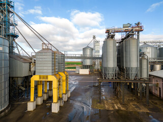 silver silos on agro manufacturing plant for processing drying cleaning and storage of agricultural products, flour, cereals and grain. Flying a drone over iron barrels of grain. quadcopter photo © Pokoman