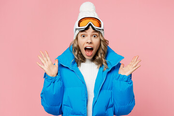 Snowboarder surprised woman wear blue suit goggles mask hat ski padded jacket spend extreme weekend spread hands say wow isolated on plain pastel pink background Winter sport hobby trip relax concept © ViDi Studio