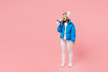Snowboarder woman wear blue suit goggles mask hat ski padded jacket hold scream aside in megaphone announces isolated on plain pink background. Winter extreme sport hobby weekend trip relax concept.