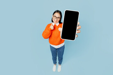Full body top view from above young woman of Asian ethnicity wear orange sweater glasses hold in...