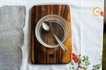 Teaspoon in a little glass bowl on a cutting board. 