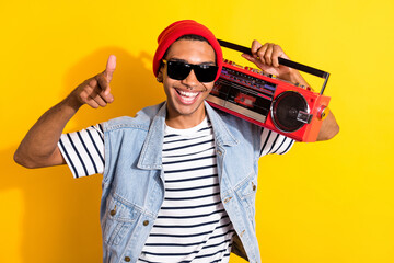 Photo of funny cheerful man carry boombox point finger camera you isolated on yellow color background