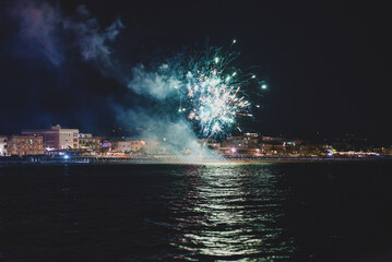 Fireworks on the coast of the city of Scauri in Italy at night.