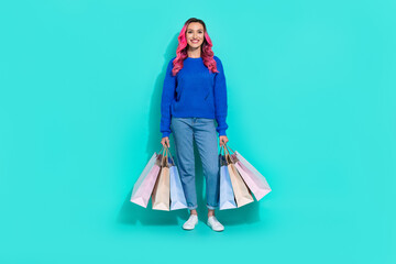 Full body length photo of young shopaholic fashionista girl wear stylish outfit hold stack shopping bags isolated on cyan color background