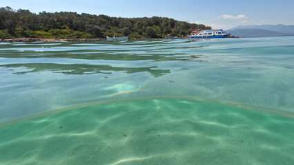 Underwater split photo of famous turquoise beach of Monolia in small complex islands of Lihadonisia...