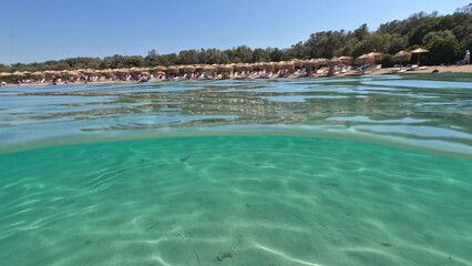 Underwater split photo of famous turquoise beach of Monolia in small complex islands of Lihadonisia...