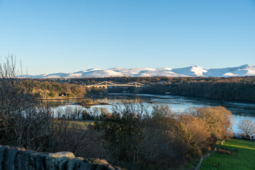 Obraz premium Wide Shot of Menai Bridge with Snowy Mountains