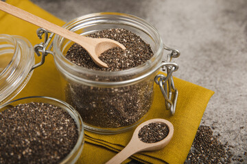Bowl and spoon with chia seeds on a black table. Superfood. Proper nutrition. Diet. Healthy food. Place for text. Place to copy.