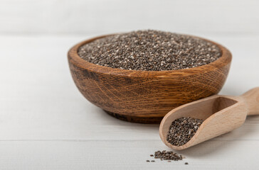 Bowl and spoon with chia seeds on a white wooden table. Superfood. Proper nutrition. Diet. Healthy food. Place for text. Place to copy.