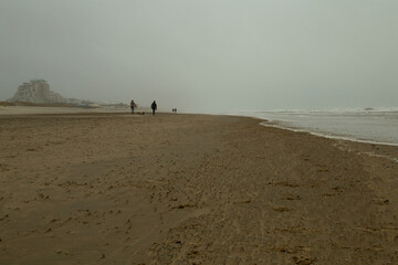 A people walking on the beach , Netherlands.