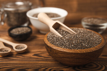 Chia seeds in a bowl and spoons on a brown textural background. Superfood. Proper nutrition. Diet. Healthy food. Place for text. Place to copy.