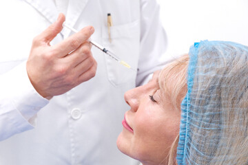 Close up picture of hand applying botox injection or acid hyaluronic to a woman
