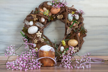 Obraz na płótnie Canvas Easter background with colored Easter wreath and blooming flowers. Kulich. Easter composition.