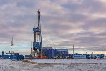 Drilling wells at an oil and gas field in the Far North. Industrial infrastructure and drilling rig. Beautiful winter sky. Polar Day