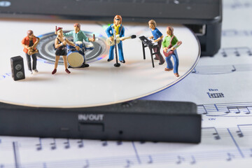 a white cd in a cd player, on which a band of music is playing a concert