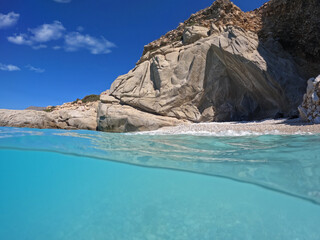 Fototapeta premium Underwater split photo of paradise exotic volcanic white rock island pebble beach with crystal clear turquoise sea in Caribbean destination island forming a blue lagoon