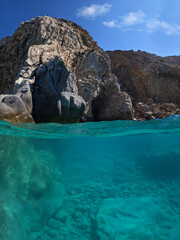 Underwater split photo of paradise exotic volcanic white rock island pebble beach with crystal clear turquoise sea in Caribbean destination island forming a blue lagoon