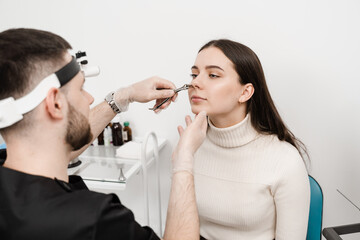 Consultation with ENT doctor. Otolaryngologist examines girl nose before procedure of endoscopy of...