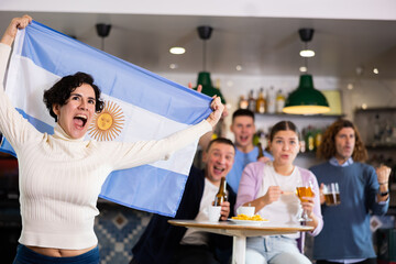 Happy fans celebrating the victory of Argentinean team in the bar