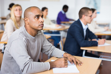 Portrait of confident man sitting in class working during group business training