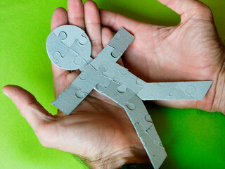 Human silhouette made with puzzle pieces on two hands that take care of their well-being