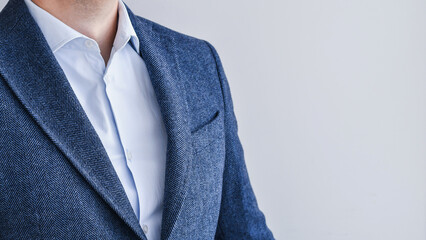 Close up of businessman wearing blue tweed blazer with light blue shirt.