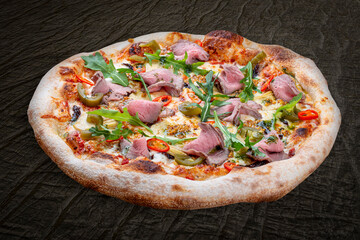 Pizza with roast beef and artichokes, jalapenos, chili, mozzarella, pesto. Neapolitan round pizza on wood background