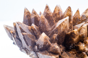 Macro focused raw natural brown sharp spiked calcite, calcite stone, natural sharp and brown carbonate crystal geode isolated on a white surface background