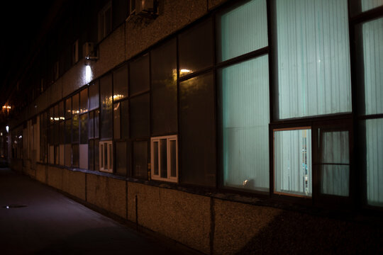 Window in building. Single window. Light in dark interior. Glass in evening.