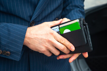 businessman in a suit opens his business leather wallet close up