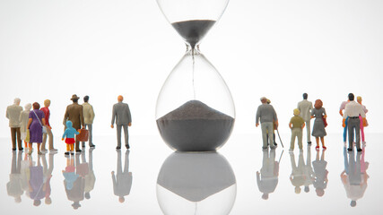 miniature people. people of different ages and statuses stand in line near the hourglass. the...