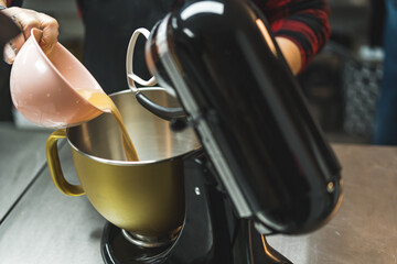Unrecognizable person baking, using stand mixer in kitchen. Using food processor to cooking in the bakery shop. High quality photo