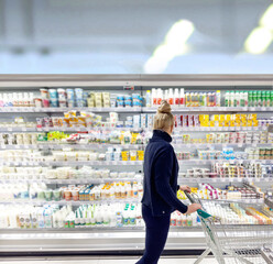Woman choosing frozen food from a supermarket freezer