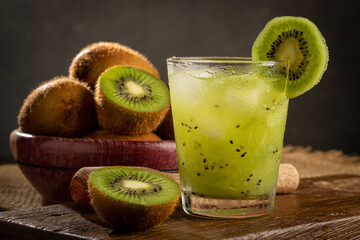 Naklejka na ściany i meble Brazilian Kiwi Caipirinha. Cachaça drink with kiwi, on wooden background.
