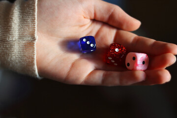 Holding gambling dices. Throwing three Six-seided dice in female's hand. Teenager is rolling three...