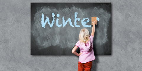 a young girl with a sponge, erasing the word winter from a blackboard