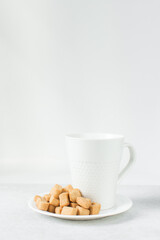 Nigerian Chin chin on a saucer next to a coffee cup, Fried chin-chin snack on a plate, Nigerian party food and small chops