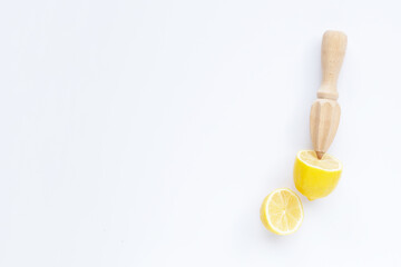 Fresh lemon with wooden juicer on white background. Copy space