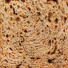 Texture of toast rye wheat whole grain bread with flax and sunflower seeds, top view, close-up square