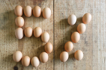 5% numeral written with chicken eggs arranged on a rustic pine wooden table, ideal for using numerals in easter season.